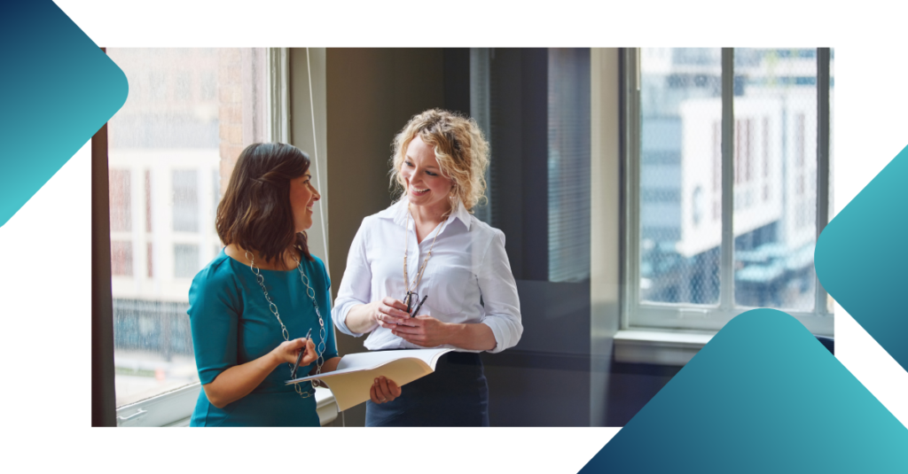 Two business professionals discussing documents in a modern office setting, representing teamwork, client communication, professional consulting, business collaboration, and relationship-driven service excellence.